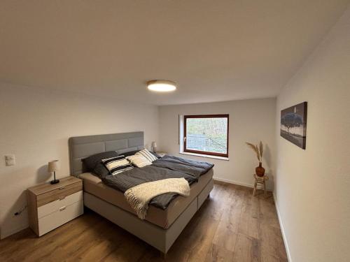 a bedroom with a bed and a window at Ferienhaus an der Burg Coraidelstein in Klotten