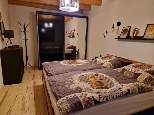 a bedroom with two beds and a mirror at Chalet Woidzauber in Zwiesel