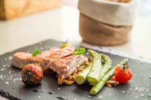 a plate of food with meat and vegetables on a table at Eco Rooms&Breakfast Tirano in Tirano