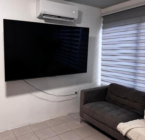 a living room with a couch and a flat screen tv at Rock Rivers in San Juan