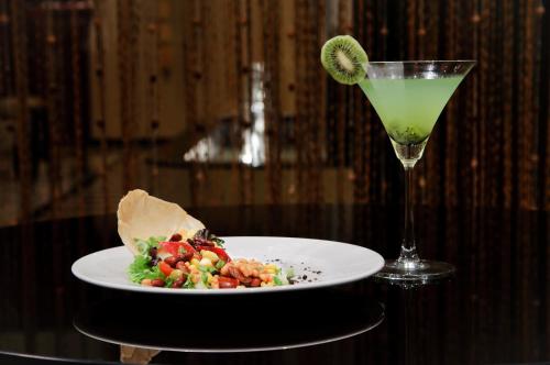a white plate with a salad and a drink on a table at Royalton Hyderabad Abids in Hyderabad