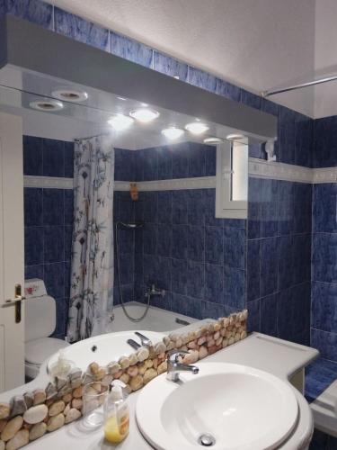 a bathroom with a sink and a toilet and a tub at Marilena Apartments Plataria in Plataria