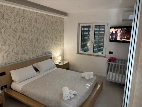 a bedroom with a bed with two white towels on it at Ilary Hause in Potenza