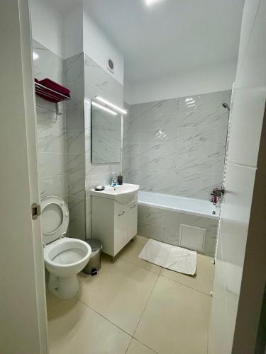 a white bathroom with a toilet and a sink at Waterfall Studio in Bucharest