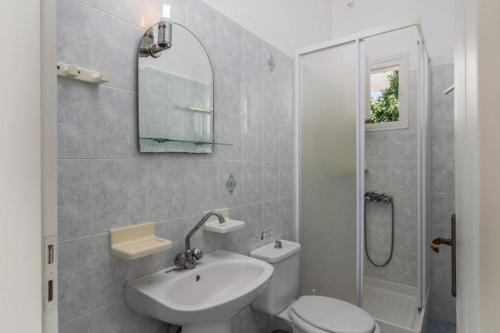 a bathroom with a sink and a toilet and a shower at Tina's Apartments in Adamantas