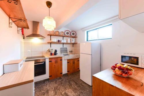 a kitchen with a white refrigerator and a bowl of fruit at Marvão Quinta da Bela Vista in Marvão