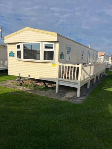 a mobile home with a porch and a deck at Luxury Seaview Retreat 8 berth beds made up for arrival FREE WIFI in Ingoldmells