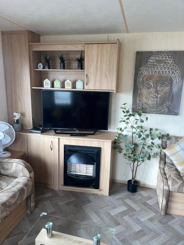 a living room with a television and a fireplace at Luxury Seaview Retreat 8 berth beds made up for arrival FREE WIFI in Ingoldmells