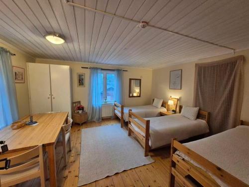 a living room with a table and a bed at Lantlivlodge i Österjörn - Midgård in Jörn