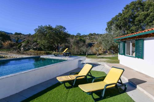 two chairs and a swimming pool in a yard at Marvão Quinta da Bela Vista in Marvão