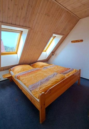 a bedroom with a wooden bed in a attic at LHMW19A12-FeWo-Seglerfruend-II in Westerbergen