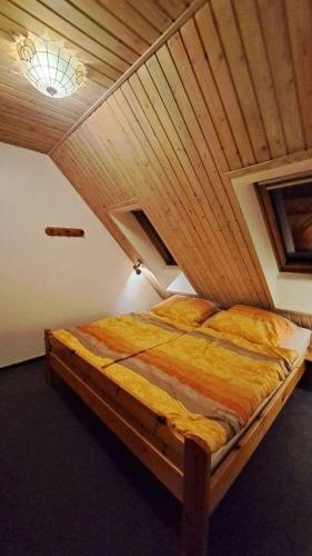 a bed in a room with a wooden ceiling at LHMW19A14-FeWo-Seglerfruend-IV in Lemkenhafen auf Fehmarn