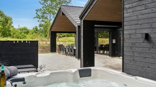 a bath tub in front of a house with a patio at Villavilla 640 - Saksild, Østjylland in Odder