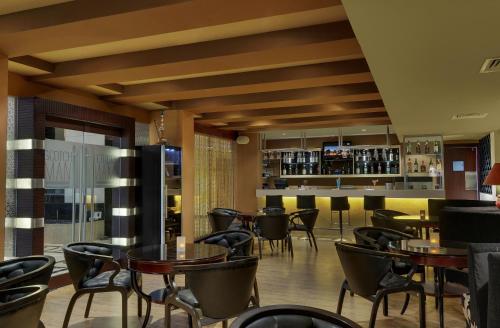 a restaurant with tables and chairs and a bar at Royalton Hyderabad Abids in Hyderabad