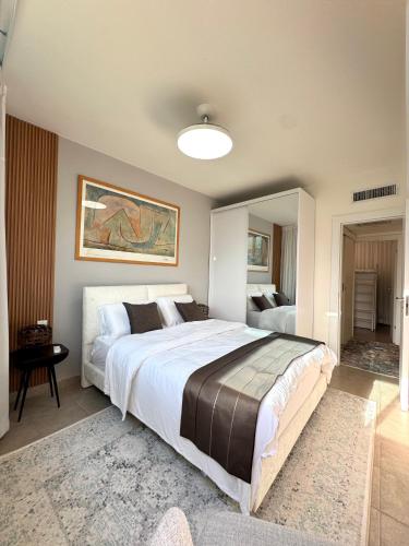 a bedroom with a large bed and a mirror at גיל נכסים #2 in Caesarea