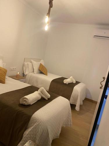 a room with two beds with towels on them at Los Llanos del Campo in Grazalema