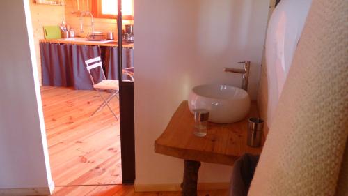 a bathroom with a sink on a wooden table at La cabane perchée du faucon in Fréchou-Fréchet