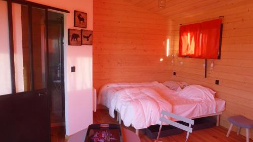 a bedroom with a bed in a wooden room at La cabane perchée du faucon in Fréchou-Fréchet