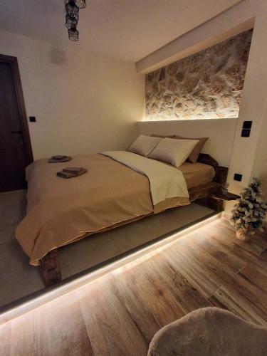 a bedroom with a large bed with a stone wall at Stella's House Lake Room 2 in Akritochori
