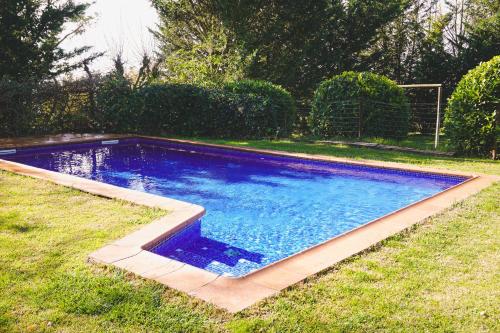 a swimming pool in the grass in a yard at Cal Terri Rural in Perafita