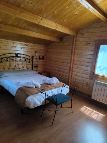 a bedroom with a bed and a chair in a room at Cabañas Miraduero in Aldeadávila de la Ribera