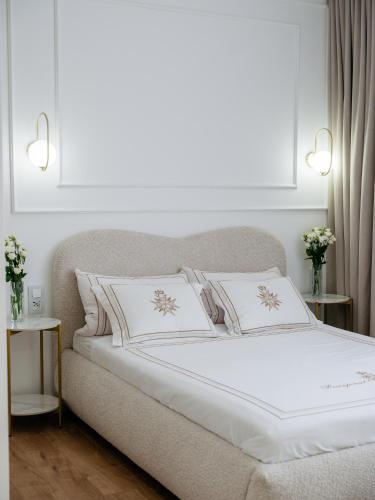 a bedroom with a bed with white sheets and pillows at Willa Ada Pokoje & Apartamenty in Karwia