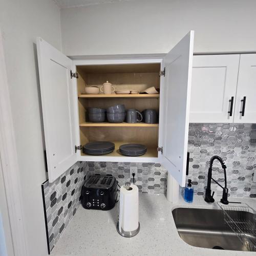 a kitchen with white cabinets and a sink at Close to the Action, Peaceful When You Return in Orlando