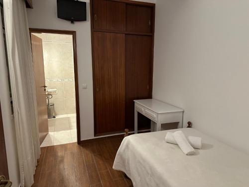 a bedroom with a bed and a bathroom with a shower at Pensão S José-CUNHA'S in Vila Nova de Tazem