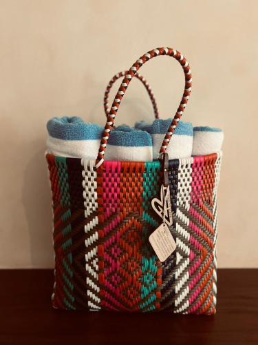 a colorful basket with a tag on it on a table at Paraiso Rainforest and Beach Hotel in Omoa