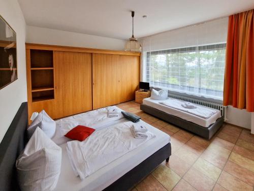 a bedroom with two beds and a large window at Bayerischer Wald, FVI Hotel und Restaurant in Neukirchen