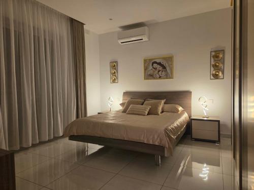 a bedroom with a bed with two lamps on it at Eivissa Apartment in Marsaskala