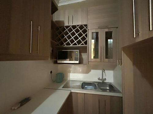 a kitchen with a sink and a microwave at Tshiamo Estate in Kuruman