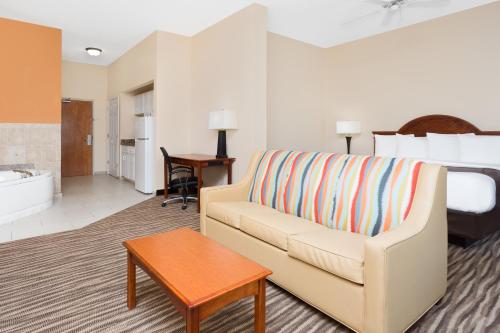 a living room with a couch and a table at Baymont by Wyndham Augusta Riverwatch in Augusta