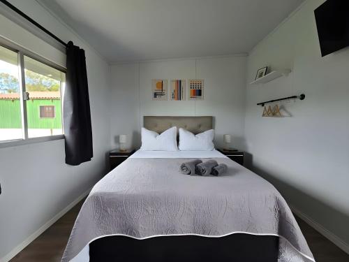 a bedroom with a large white bed with two pillows at Maridalba 2 in La Coronilla