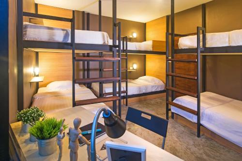 a room with bunk beds and a desk with a computer at Srisuksant Square in Krabi town
