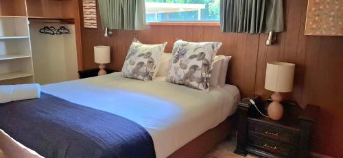 a bedroom with a bed with pillows and two lamps at PAK House Central - Spacious 4 Bedroom New Listing! in Echuca