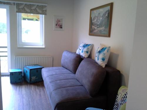a living room with a brown couch and a window at Saghäusl in Mitterkleinarl