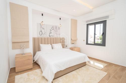 a white bedroom with a large bed and a window at Luxury Villa with Private Pool STR1 in Tangier