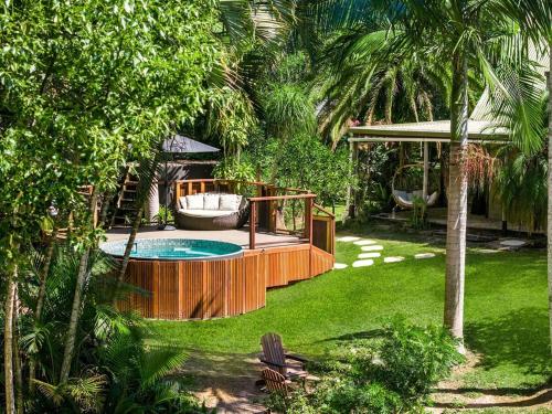 a backyard with a hot tub and a swing at Figtree Creek Retreat in The Pocket