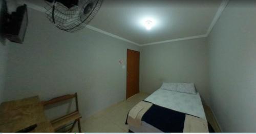 a bedroom with a bed and a light on the ceiling at Cedro Assis hotel in Assis