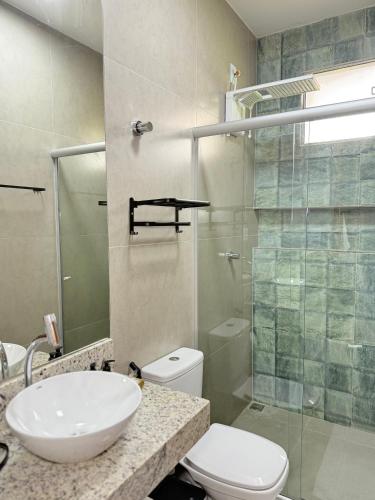 a bathroom with a sink and a toilet and a shower at Pousada Vista do Voo in Brumadinho