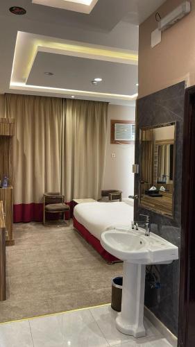 una stanza d'albergo con un letto e un lavandino di وابل للوحدات السكنية a Abha