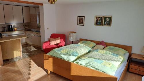 a bedroom with a bed and a kitchen at Retrowohnung Lindenhof Oberndorf in Oberndorf