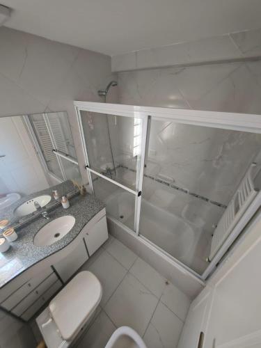 a white bathroom with a toilet and a sink at Una perla a metros del mar in Mar del Plata