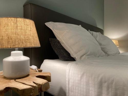 a bedroom with a bed and a table with a lamp at Bungalow 140 in Maarkedal