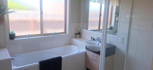 a bathroom with a tub and a sink and a bath tub at Annesley Central in Echuca