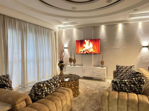 a living room with couches and a tv on a wall at LuX EXECUTIVE 2 BEDROOM in Eldoret