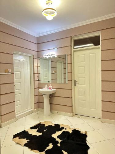 a bathroom with a cow rug and a sink at LuX EXECUTIVE 2 BEDROOM in Eldoret