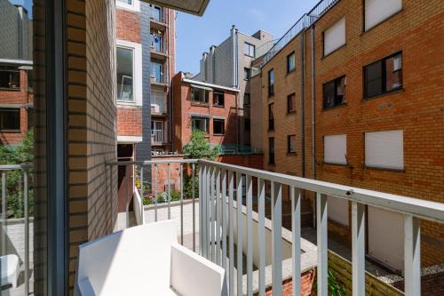 een balkon met een witte balustrade en enkele gebouwen bij Blankeduyn Koksijde in Koksijde