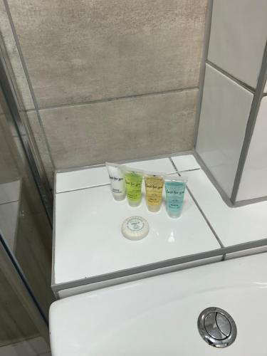 three cups sitting on top of a toilet in a bathroom at The Grove En-Suite Rooms in Bristol